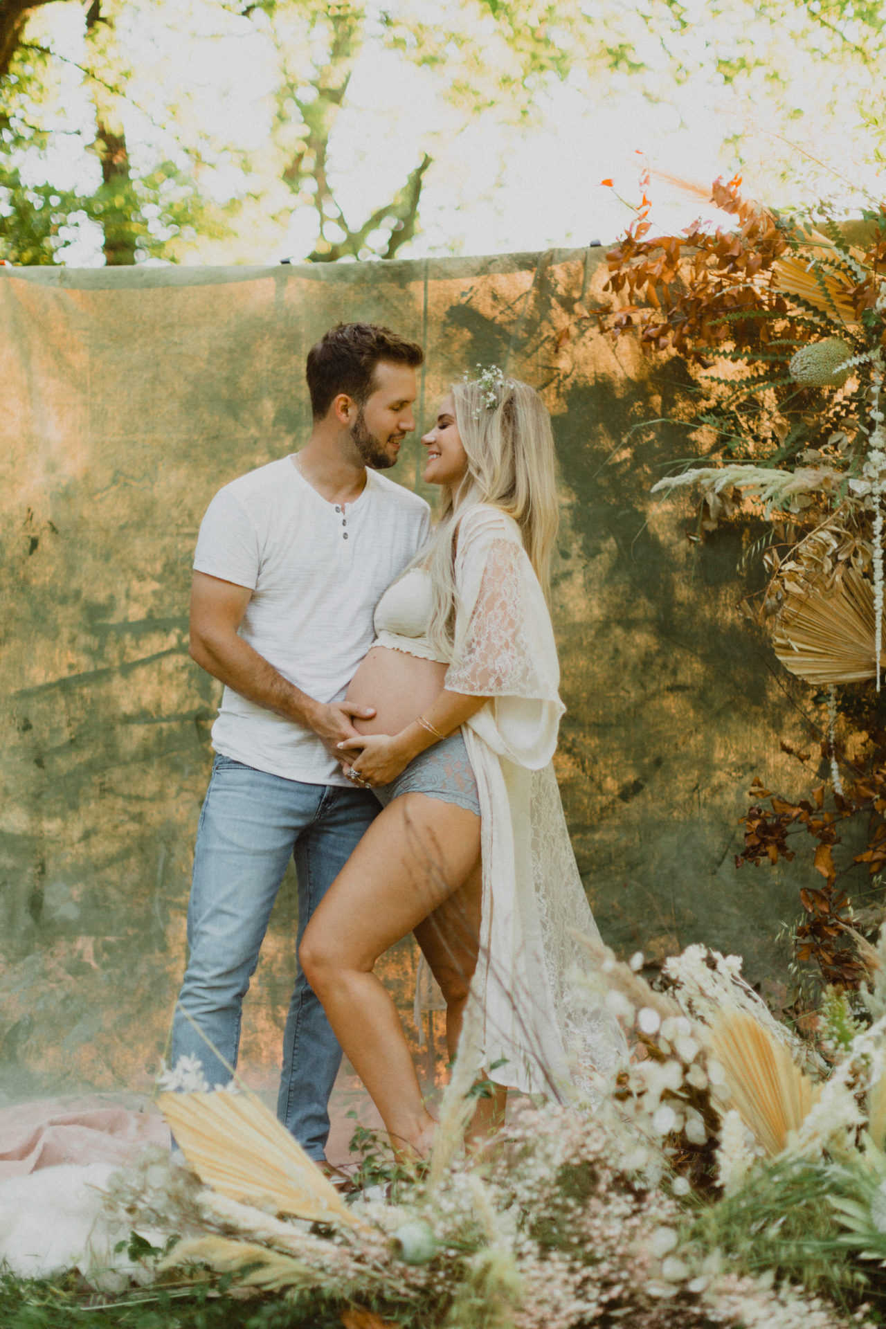 his and hers boudoir outdoor maternity photoshoot with wildflowers